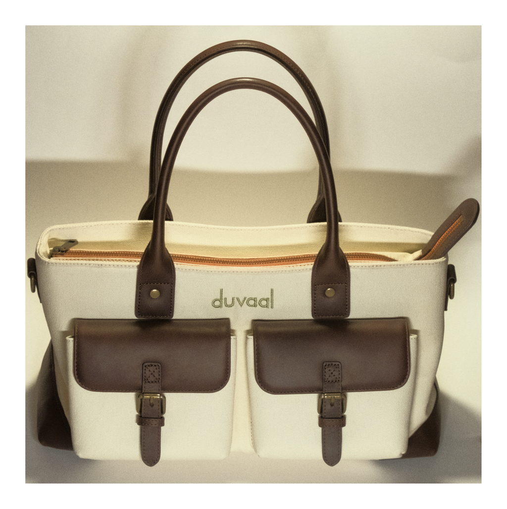 Beige and brown handbag with dual handles and front pockets, duvaal logo visible