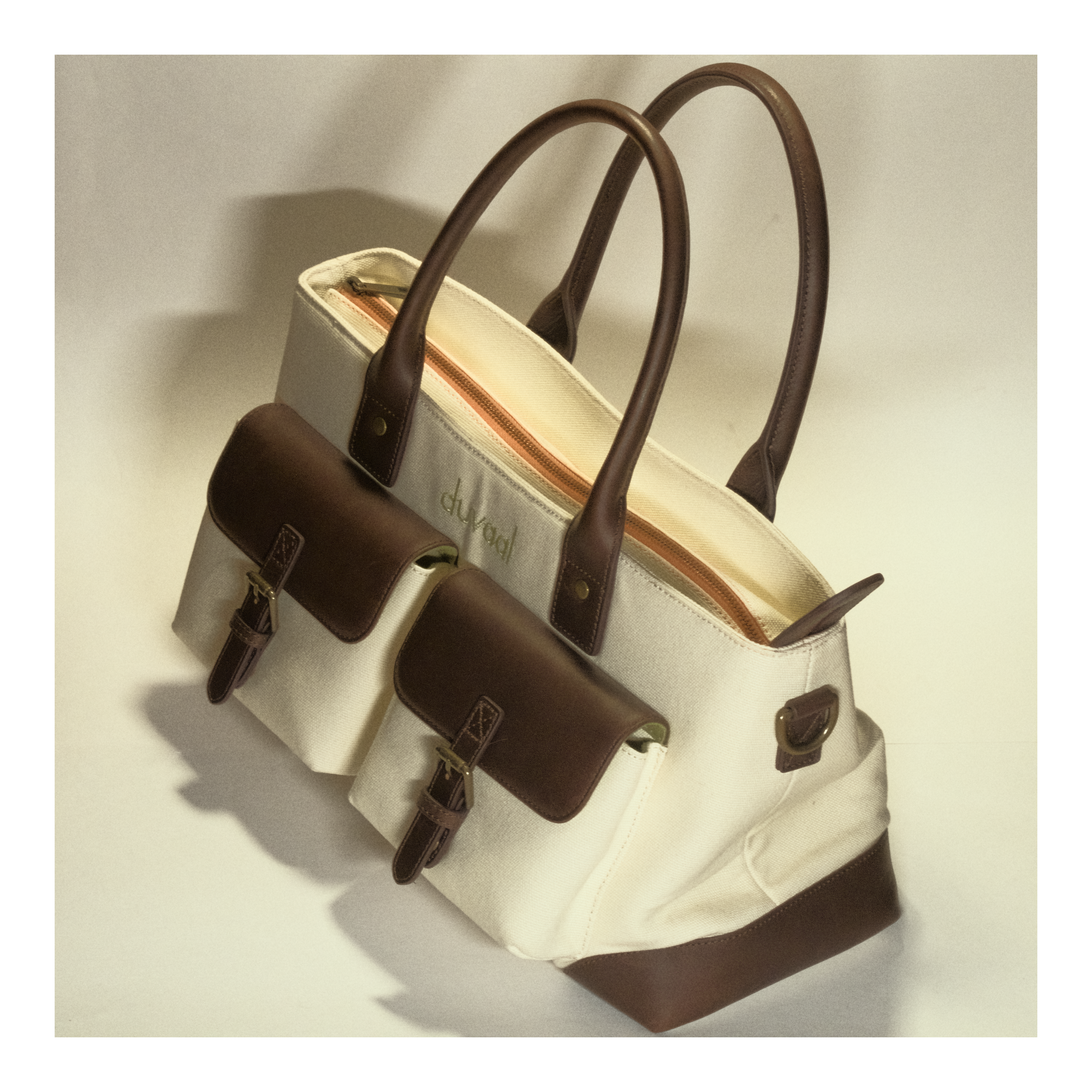 Canvas tote bag with brown leather handles and pockets, stylish and spacious design